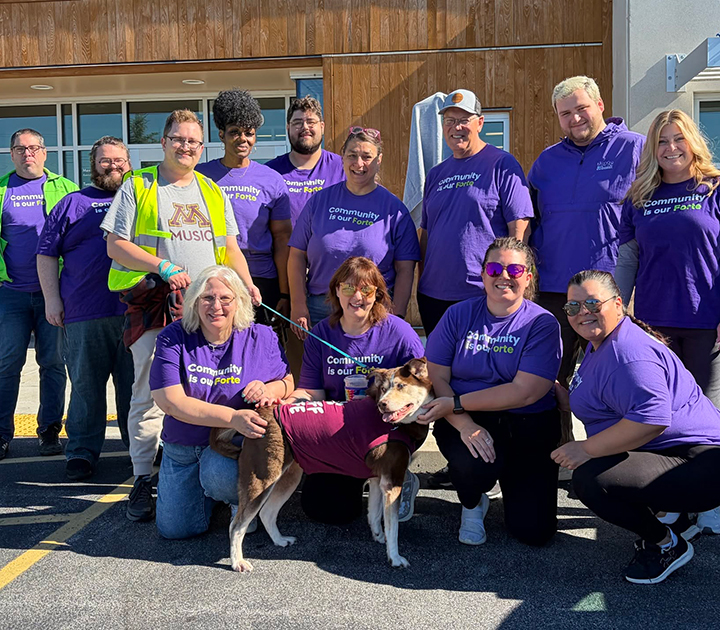 group of Forte Bank volunteers posing with a dog