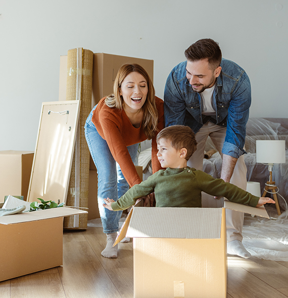 couple and son playing in moving boxes