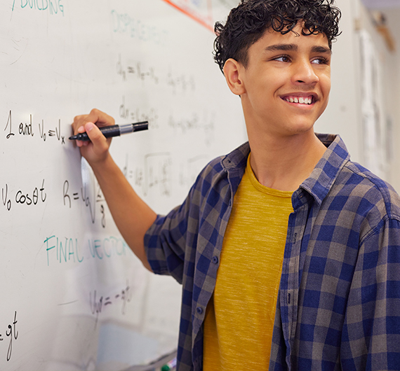 student writing on large marker board